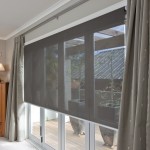 Side view of large window with roller blind screen in charcoal colour fitted with side curtains over top.